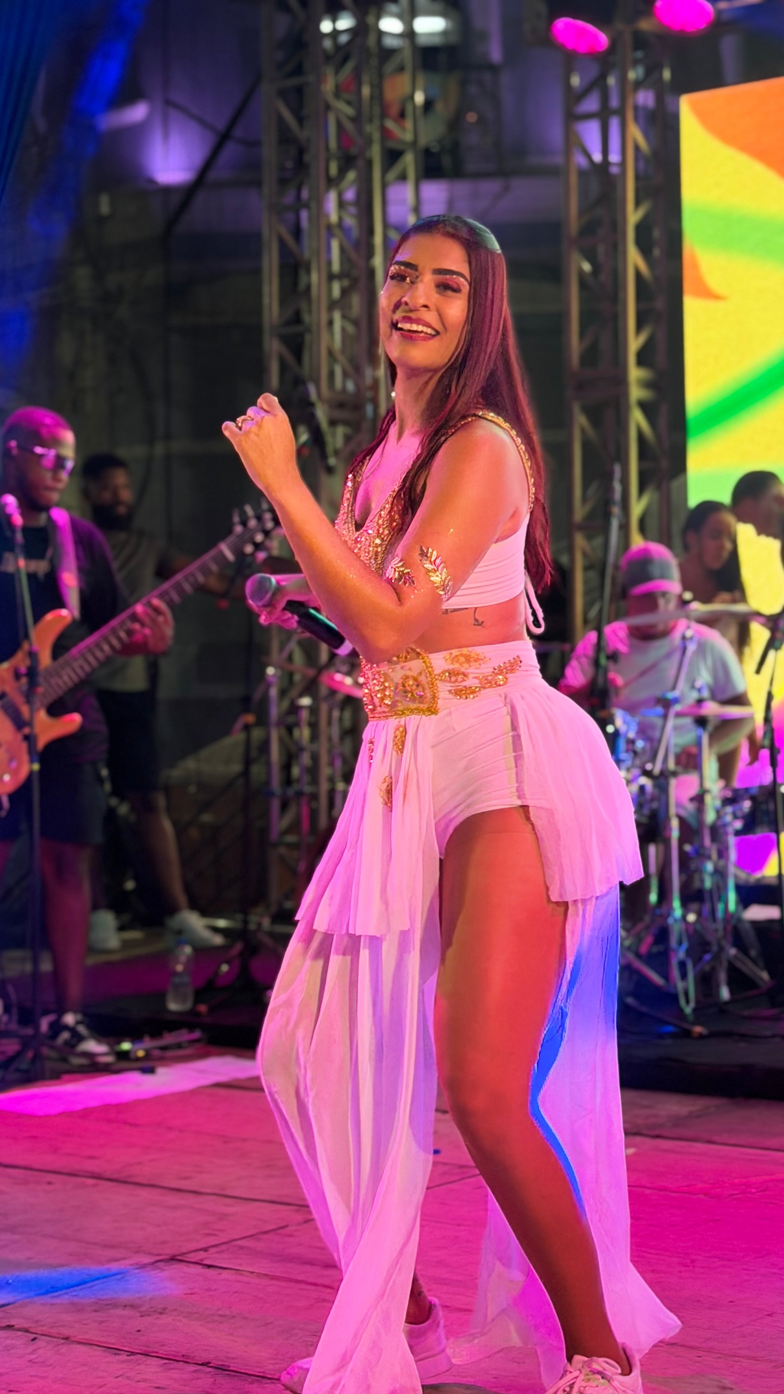 Carol Ferreira sorrindo no palco durante show ao vivo em Juiz de Fora